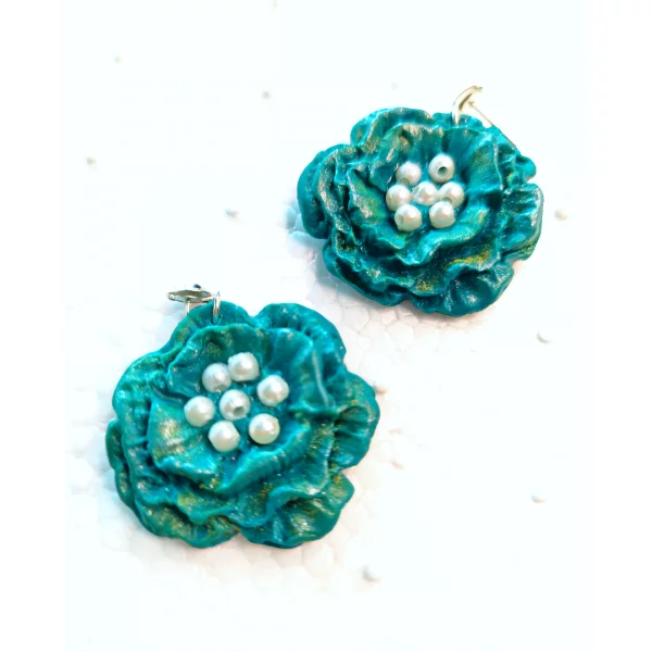 A chunky flower dangle in bluish-green color for mesmerizing happiness-kicking outlook. decorated with white beads in the middle, it builds more fun-packed, decent look. Perfect for earrings for sensitive ears.