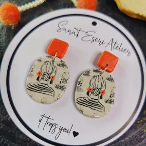 Oval Shaped Imprinted Girl with a Bun Earrings in Orange and White